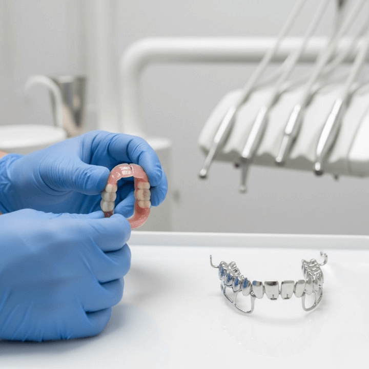 A collection of complete dentures and partial dental bridges displayed on a clean white surface.